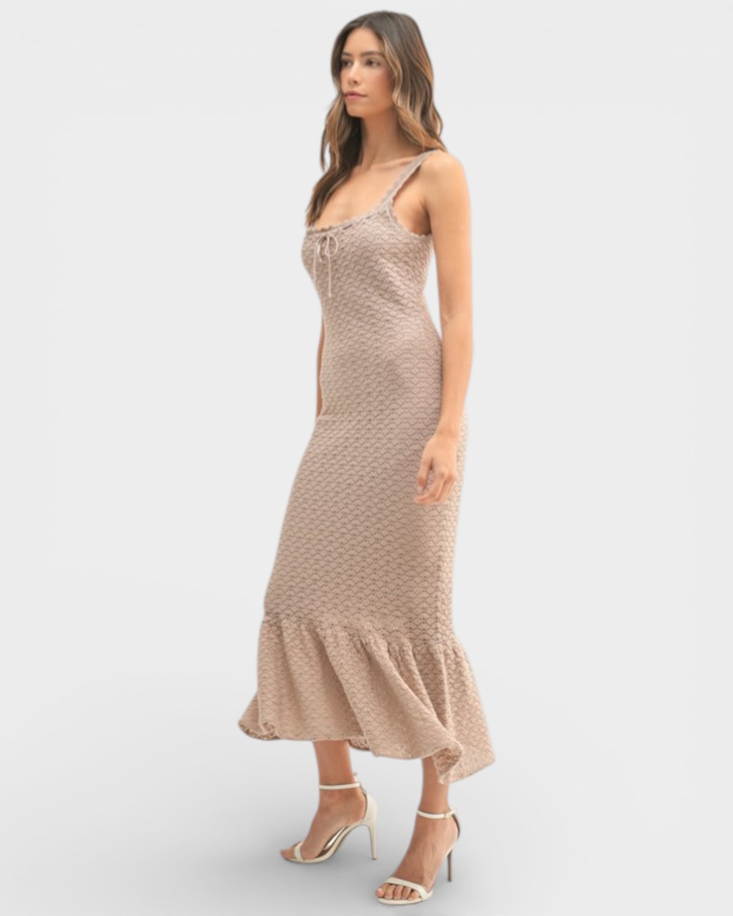 Woman wearing a beige patterned dress on a white background