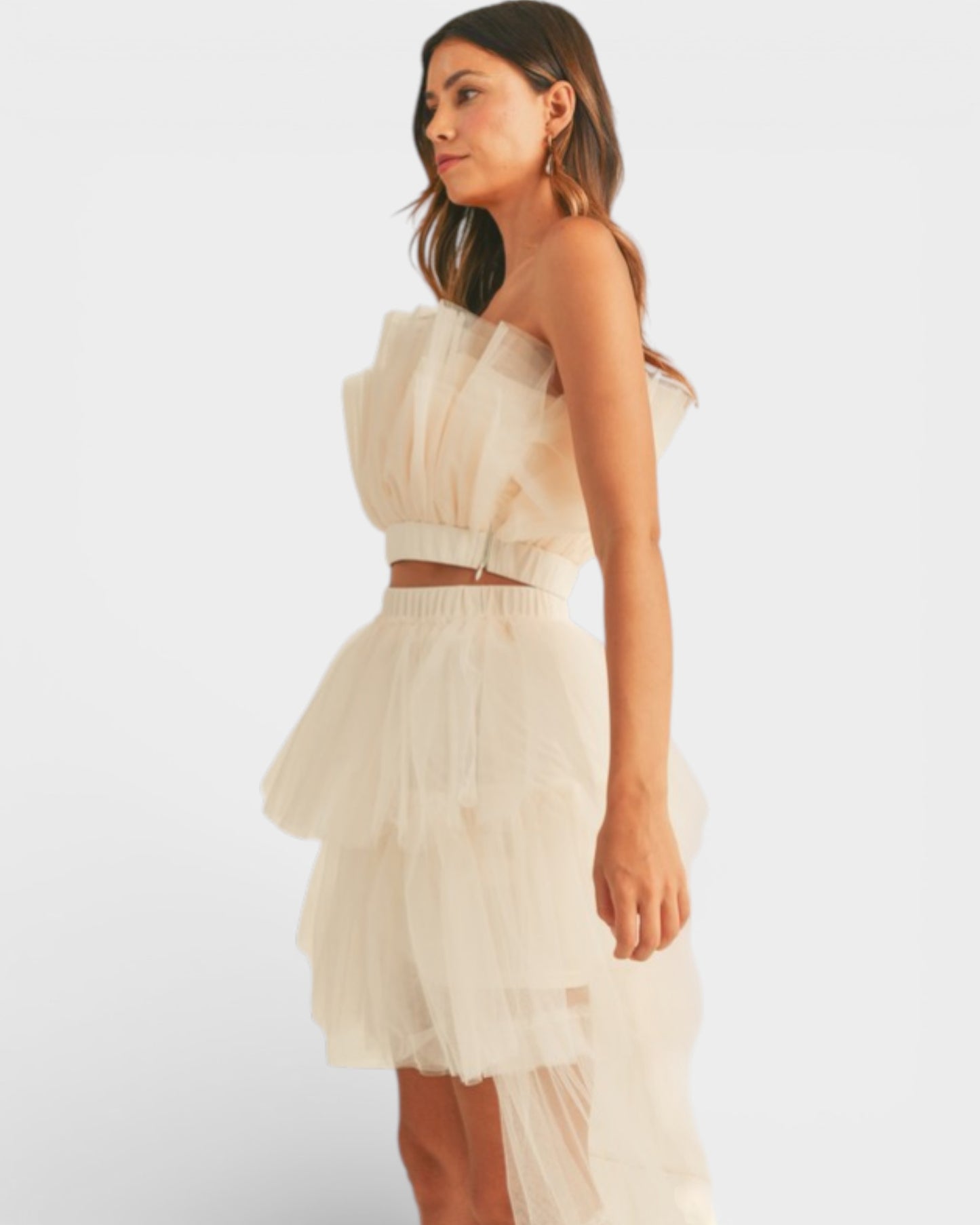 Woman wearing a beige strapless dress on a white background