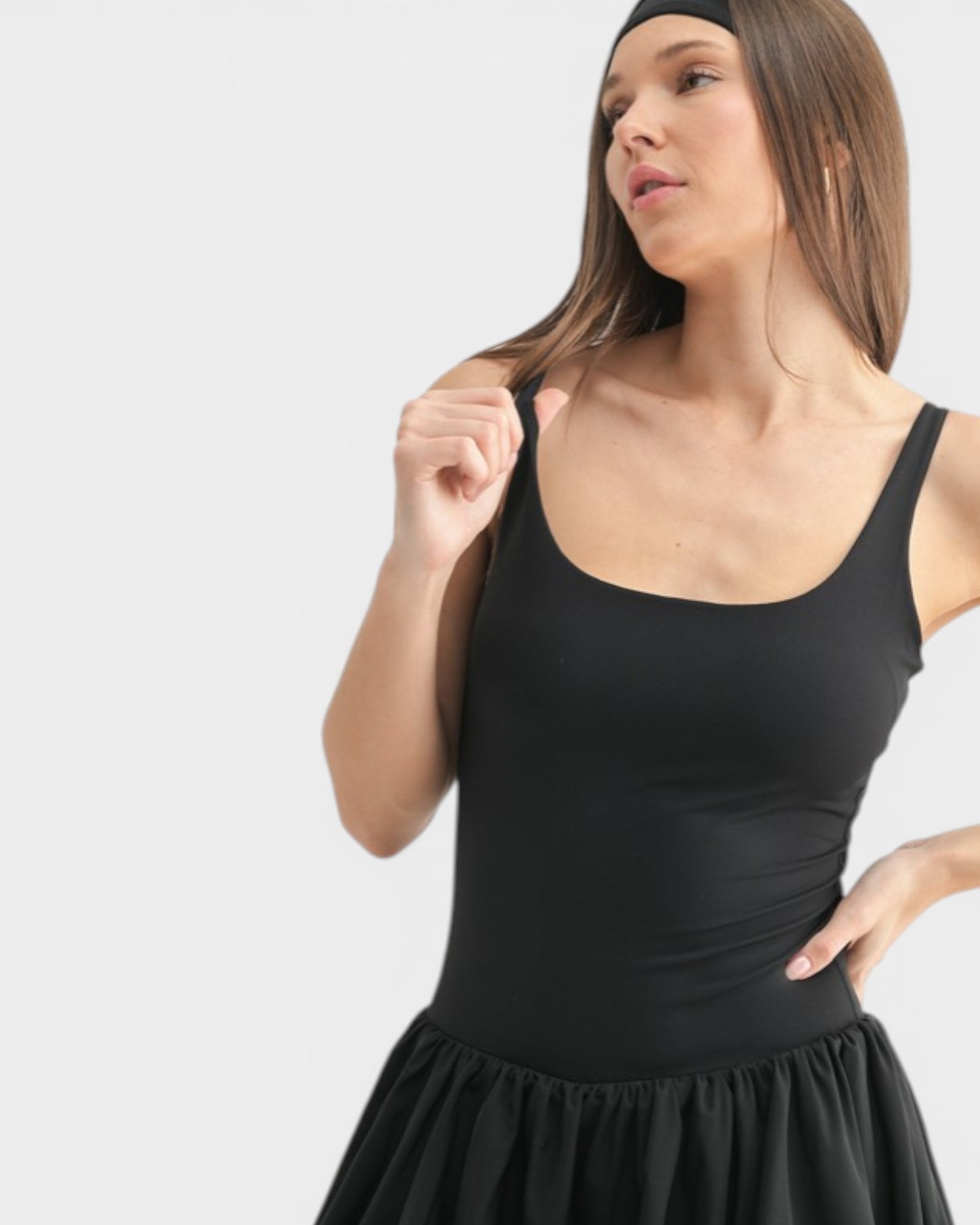 Woman wearing a black sleeveless dress against a white background
