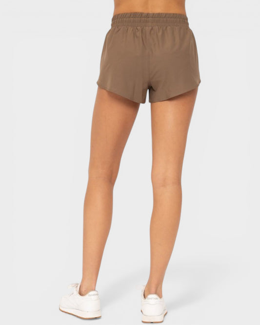 Person wearing brown shorts on a white background