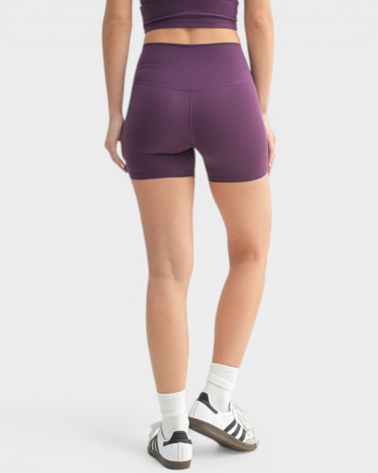 Person wearing purple athletic shorts on a white background