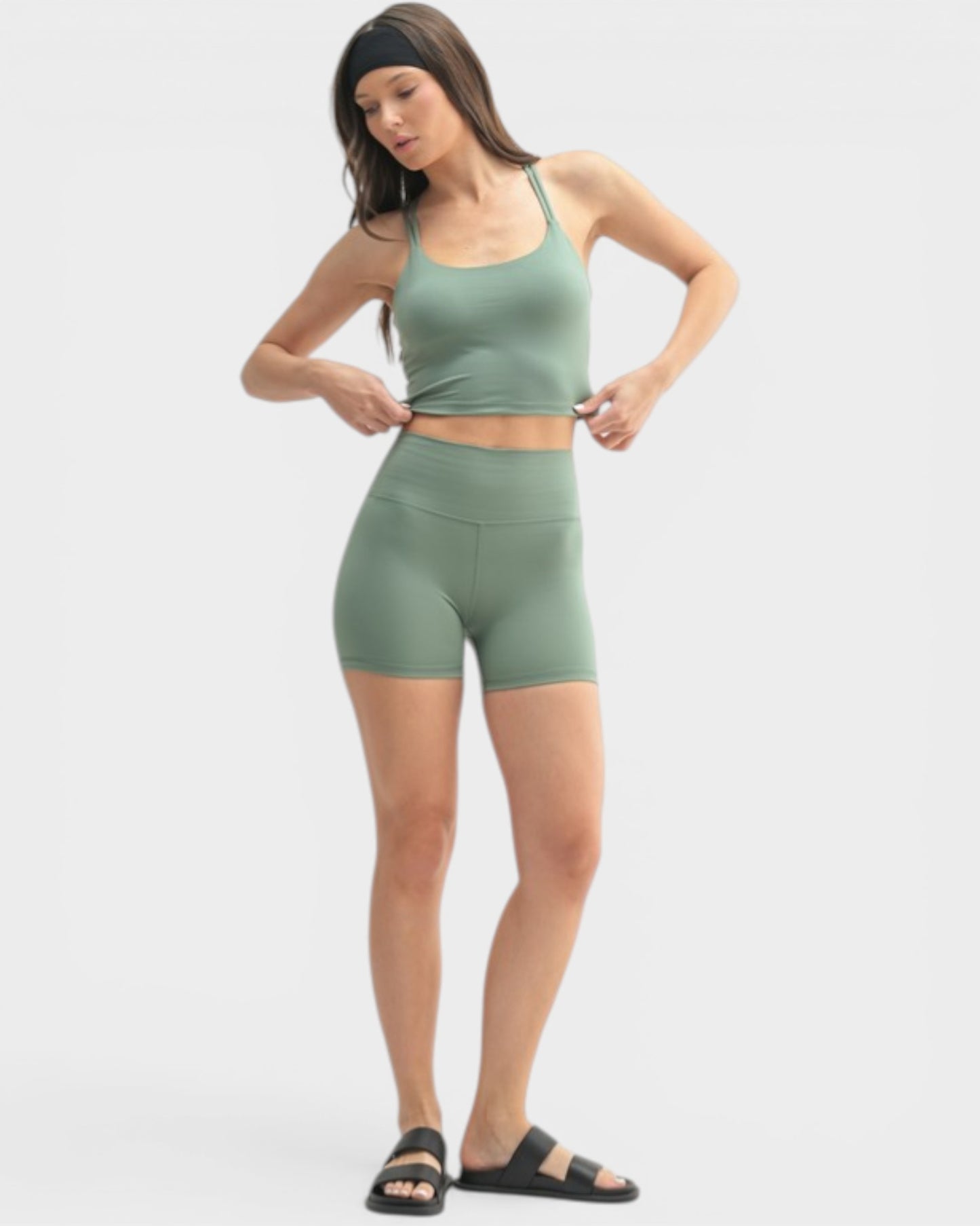 Woman wearing a green athletic outfit on a white background