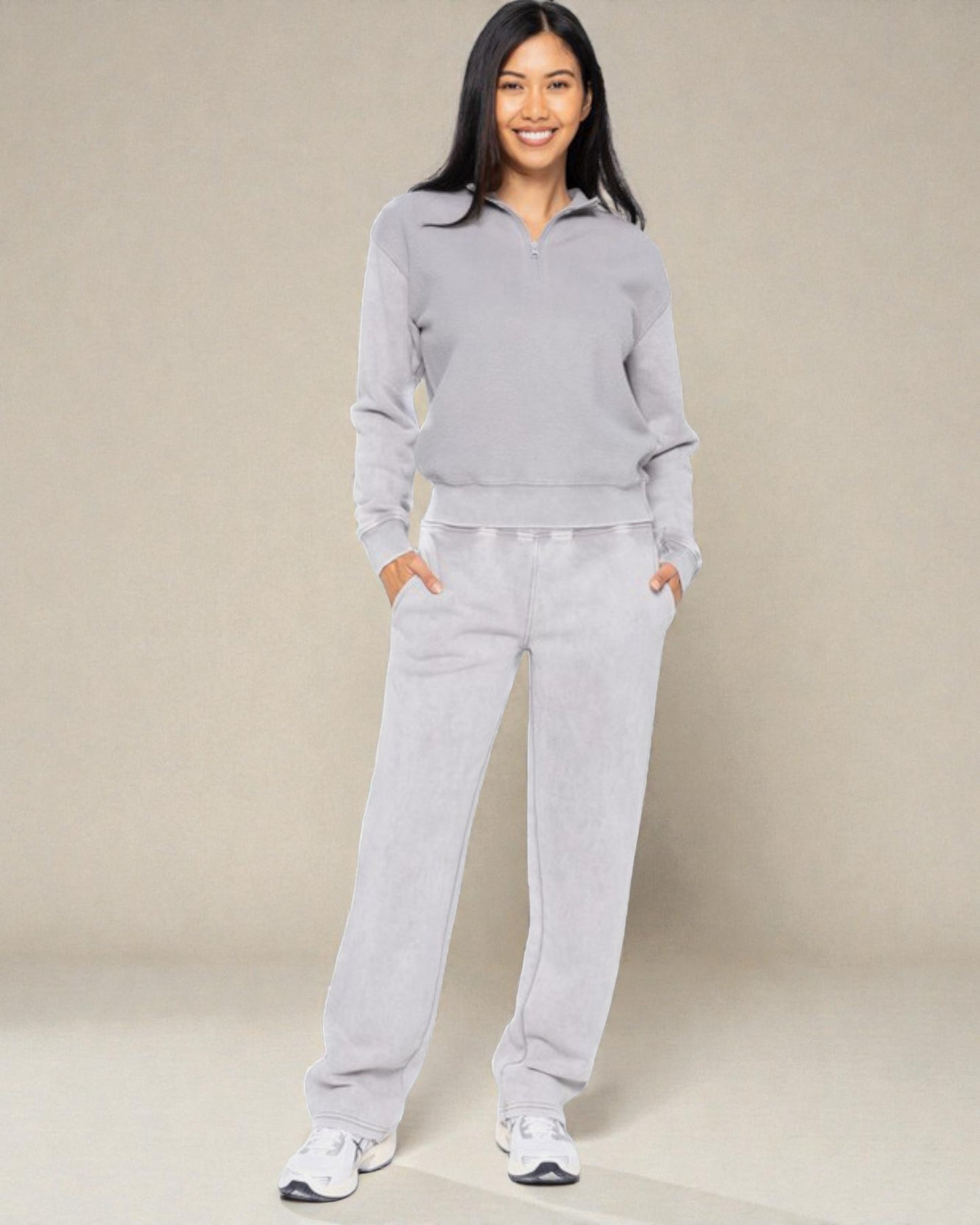 Woman wearing a gray sweater and pants set on a beige background