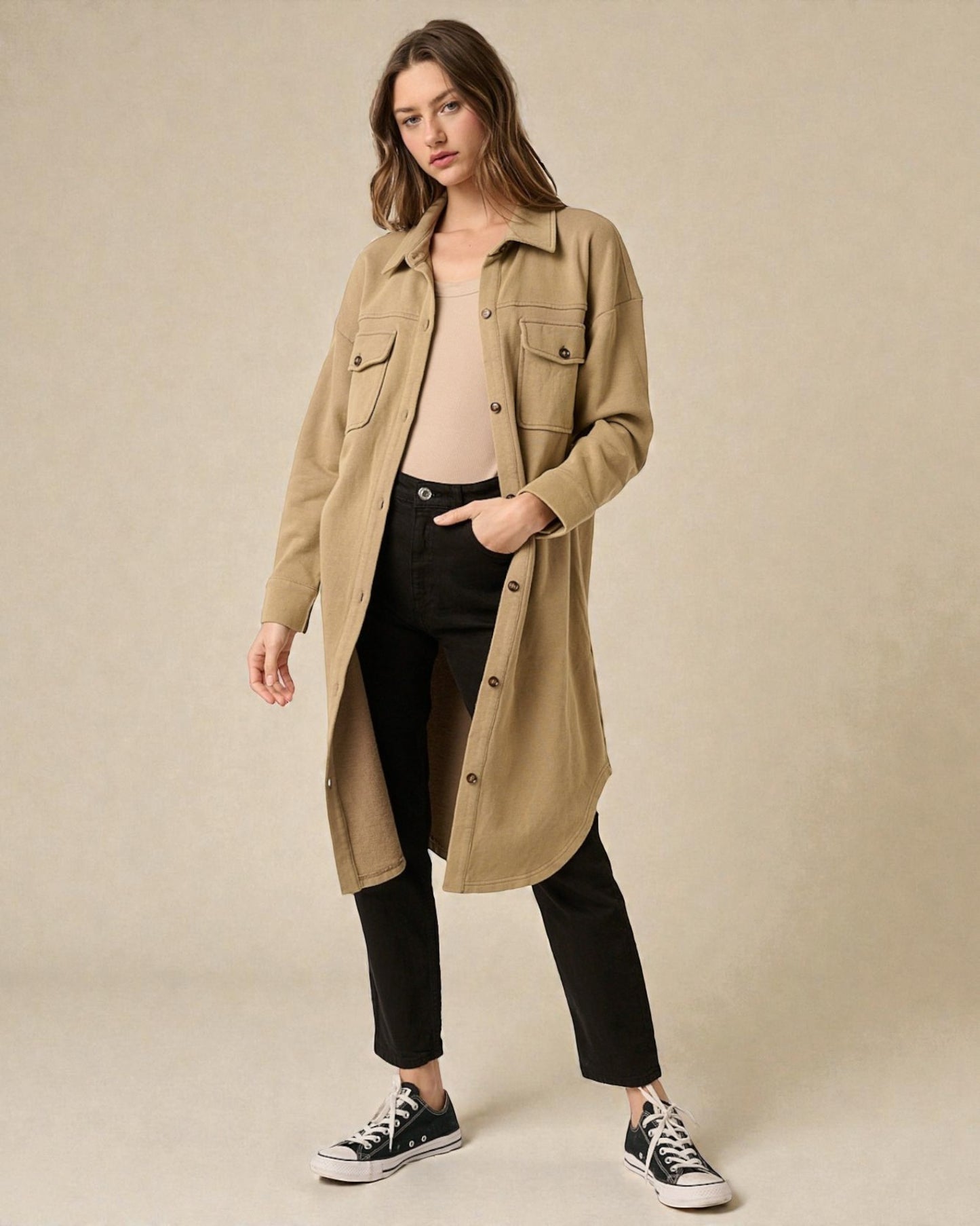 Woman wearing a beige trench coat on a beige background