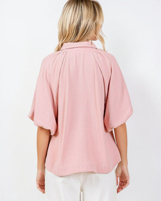 Woman wearing a pink blouse with a white background