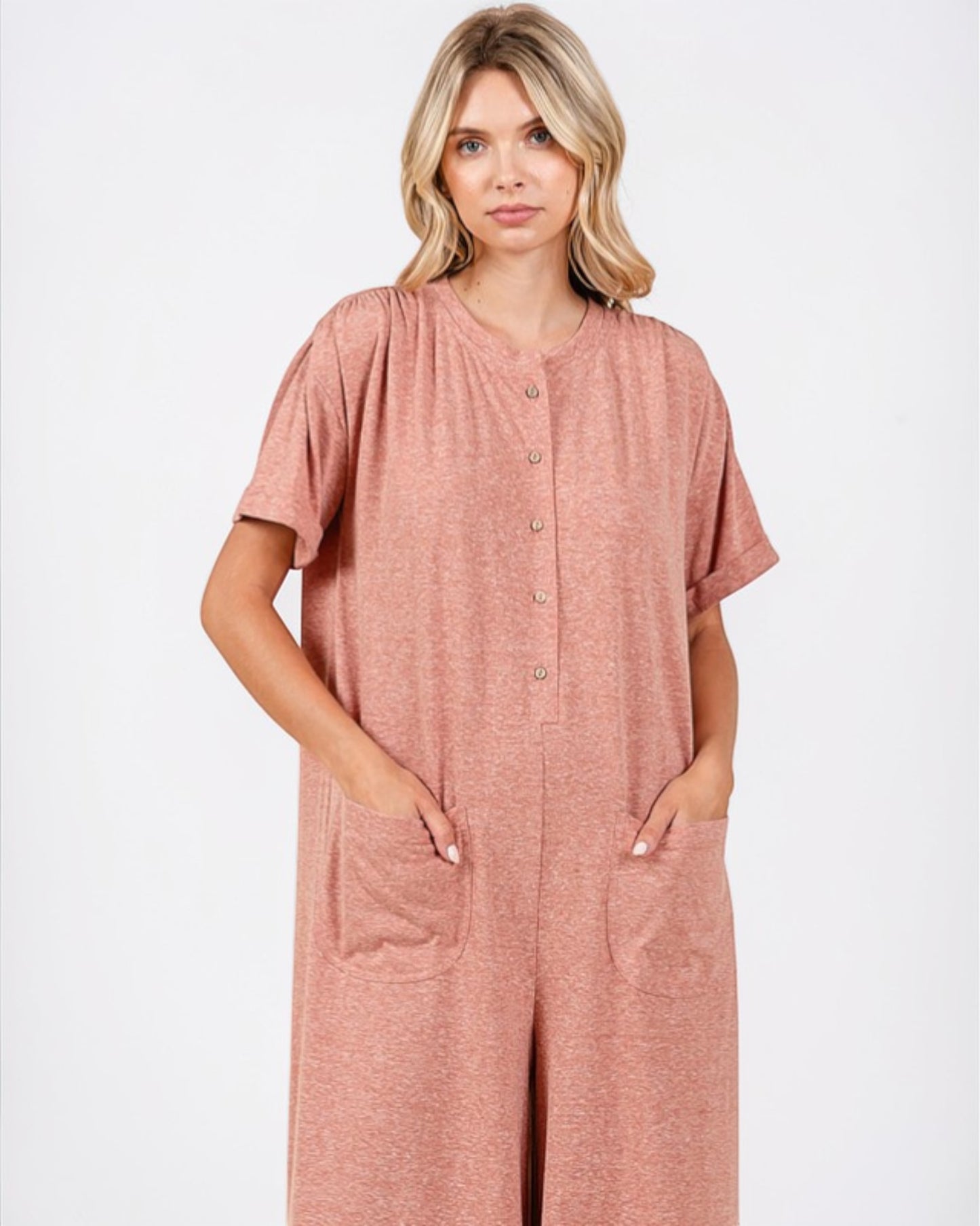 Woman wearing a pink jumpsuit on a white background