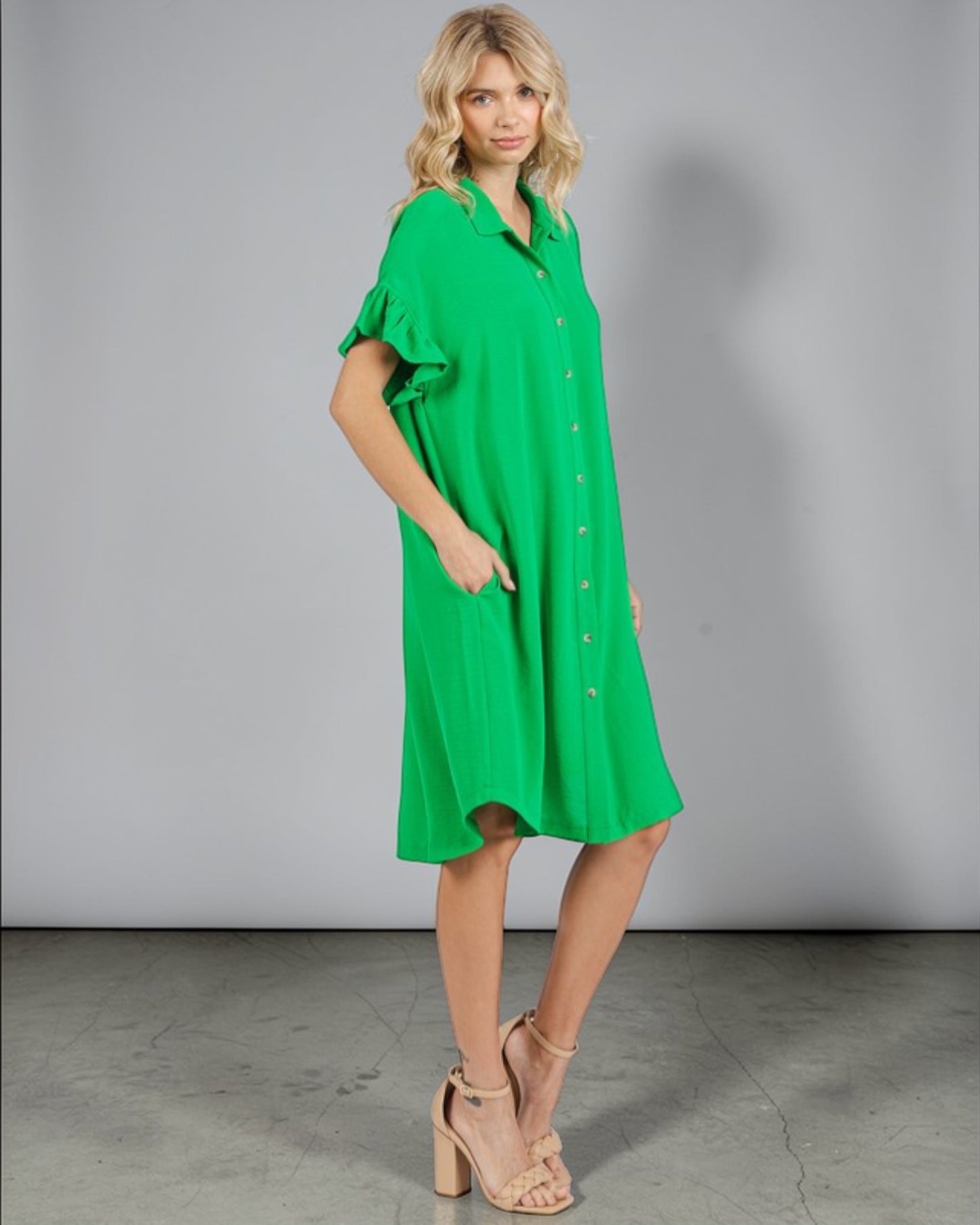 Woman wearing a green dress against a gray background