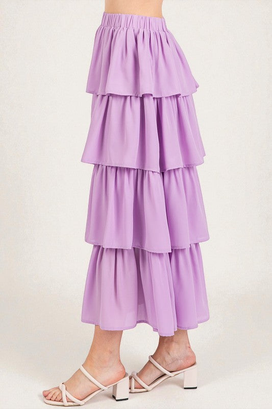 Purple tiered skirt worn by a person on a white background