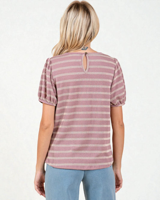 Woman wearing a pink and white striped blouse with puff sleeves on a white background