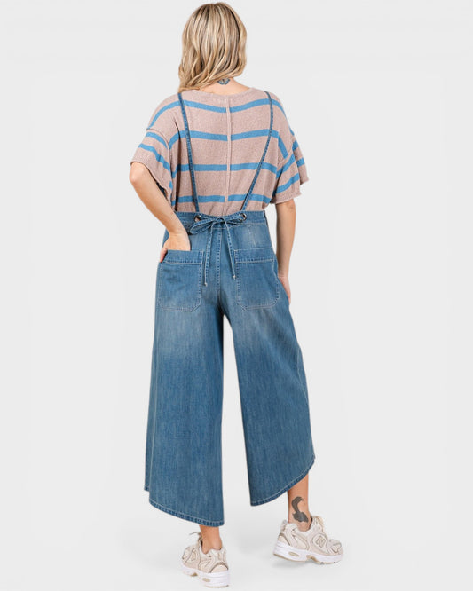 Woman wearing a striped shirt and denim wide-leg pants on a white background