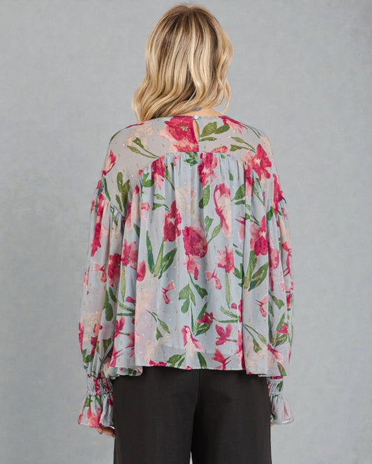 Woman wearing a floral blouse with a gray background