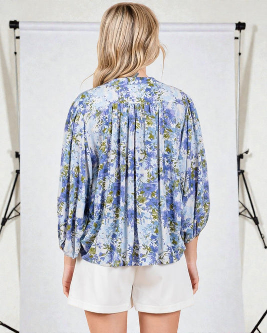 Woman wearing a blue floral blouse against a white background
