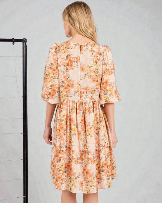 Woman wearing a floral dress against a gray background