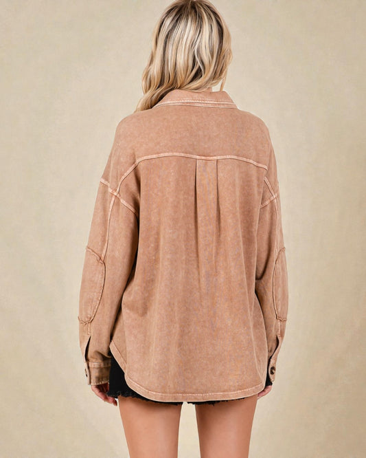 Person wearing a brown jacket on a beige background