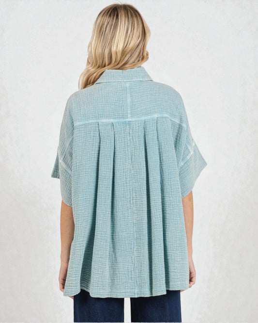 Person wearing a light blue checkered shirt on a white background