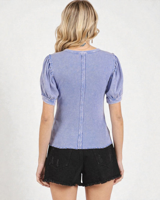 Woman wearing a blue denim top with puffed sleeves on a white background