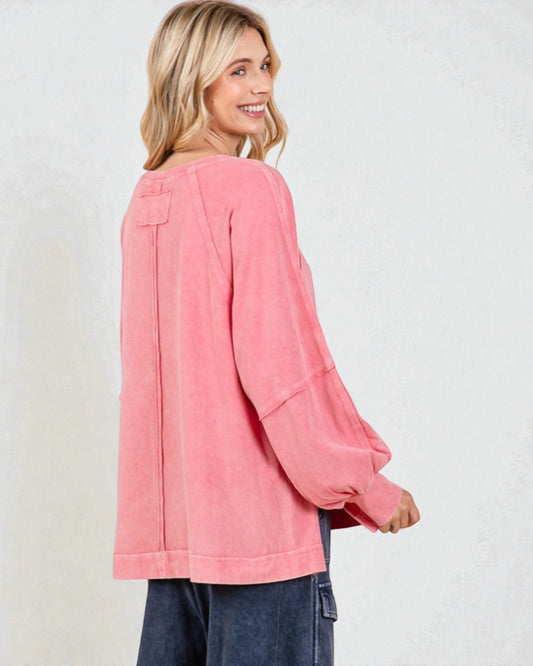 Woman wearing a pink long-sleeve top on a white background