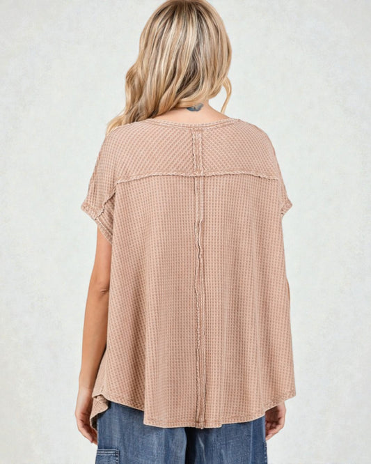 Woman wearing a beige checkered blouse with short sleeves on a white background