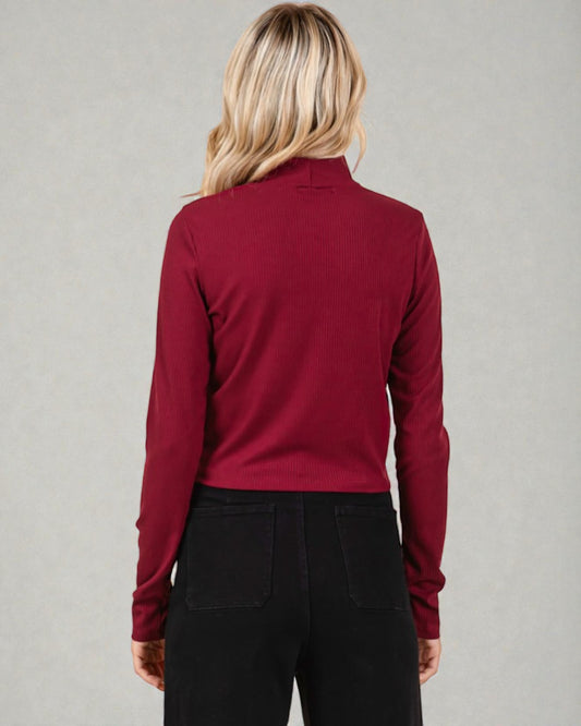 Person wearing a red long-sleeve shirt against a gray background