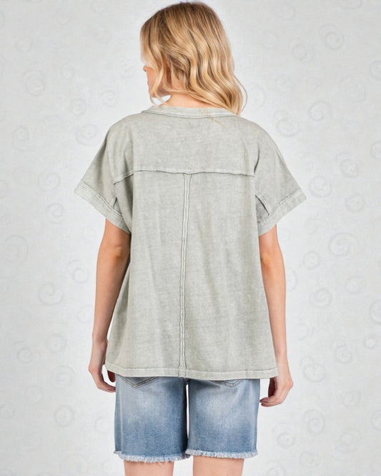 Person wearing a light gray t-shirt and denim shorts on a white background