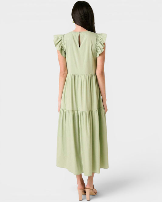 Woman wearing a light green dress with ruffled sleeves on a white background