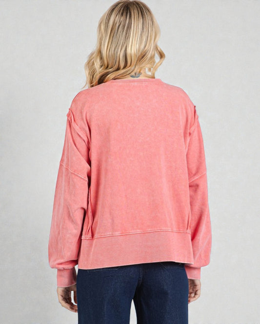 Person wearing a pink sweatshirt on a plain background