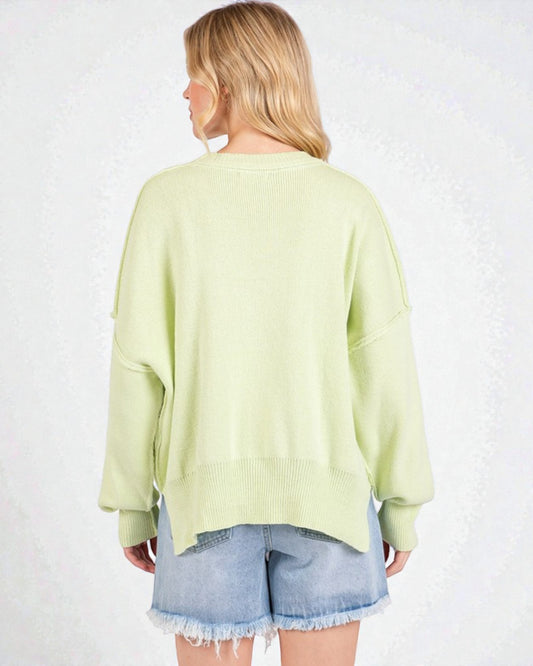 Person wearing a light green sweater and denim shorts on a white background