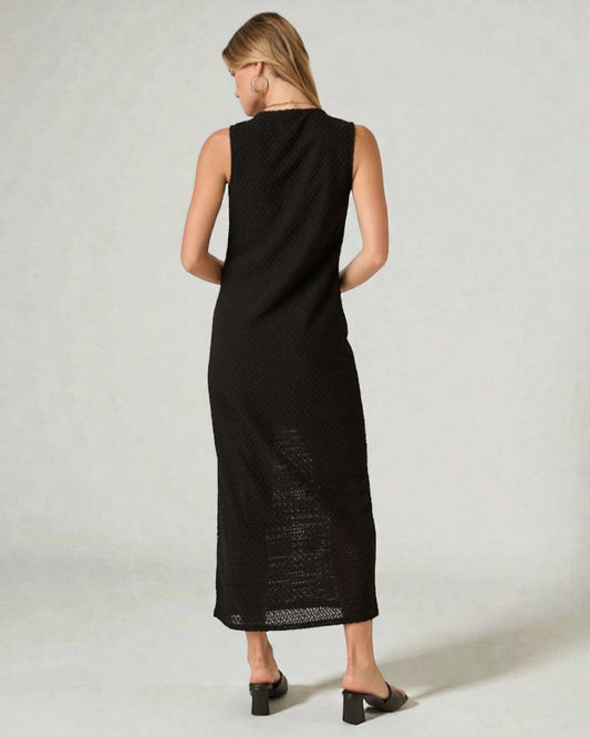 Woman wearing a black sleeveless dress against a white background