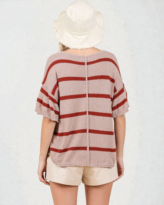 Person wearing a striped shirt and hat on a plain background