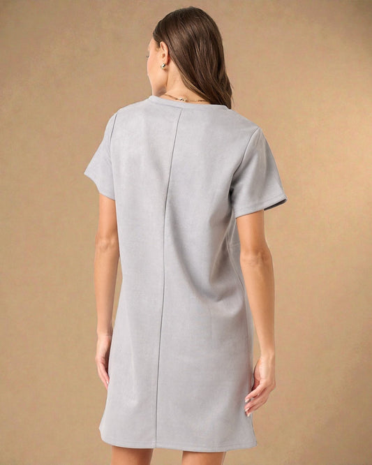 Woman wearing a light gray dress against a beige background