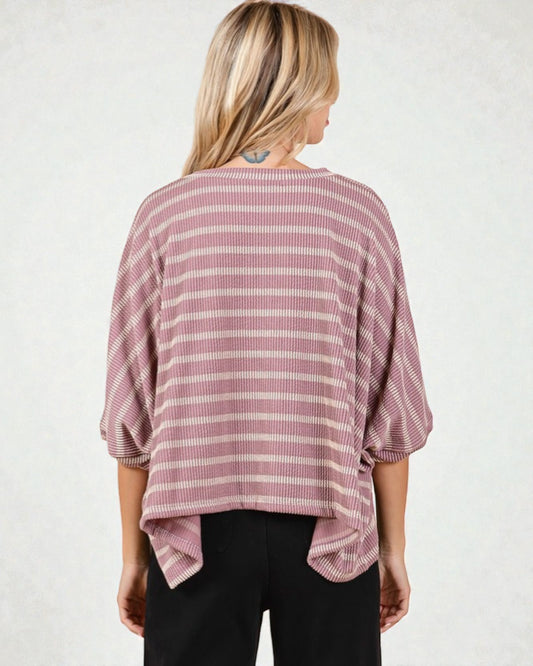 Woman wearing a pink and white striped shirt against a plain background