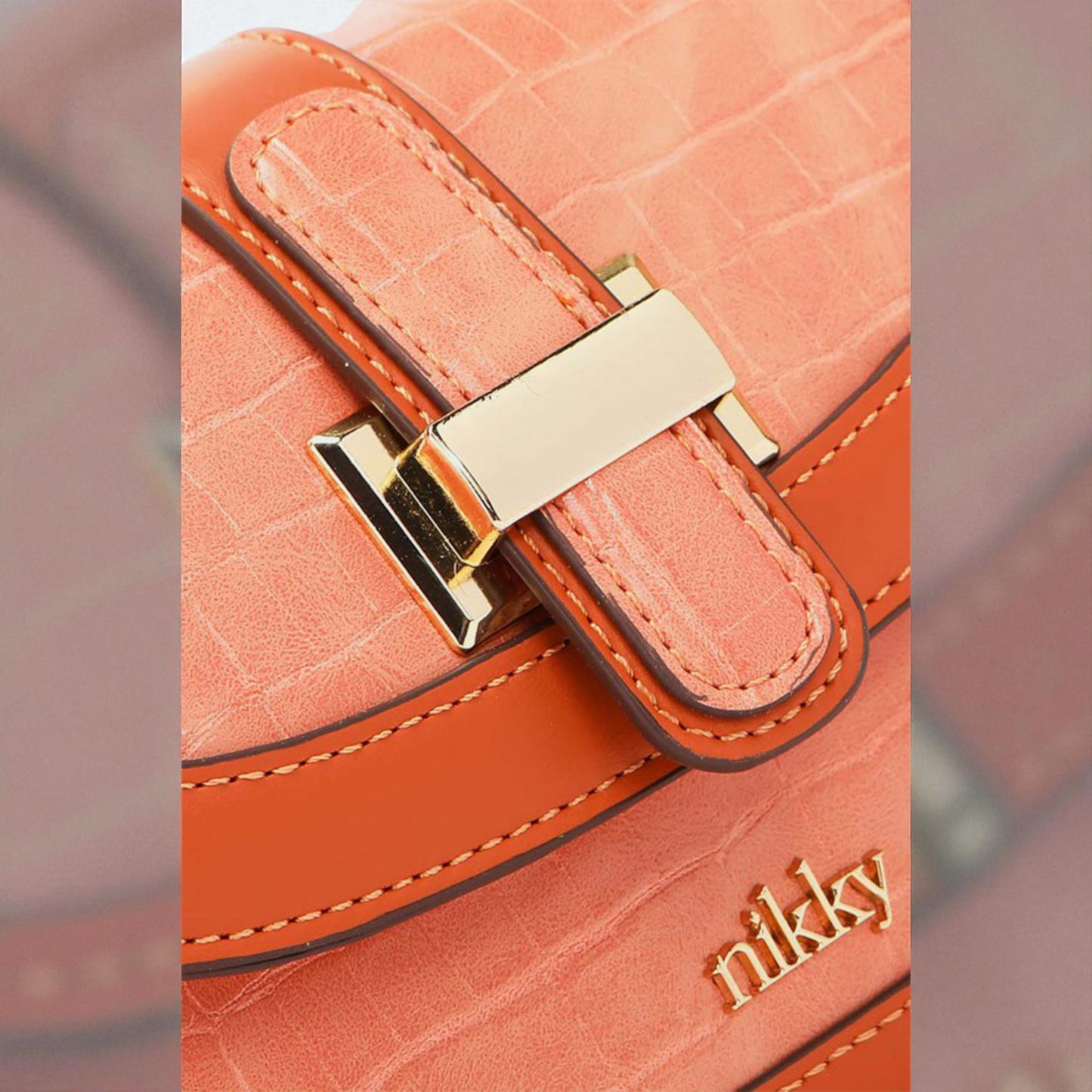 Close-up of a pink handbag with gold accents and 'nikky' branding.
