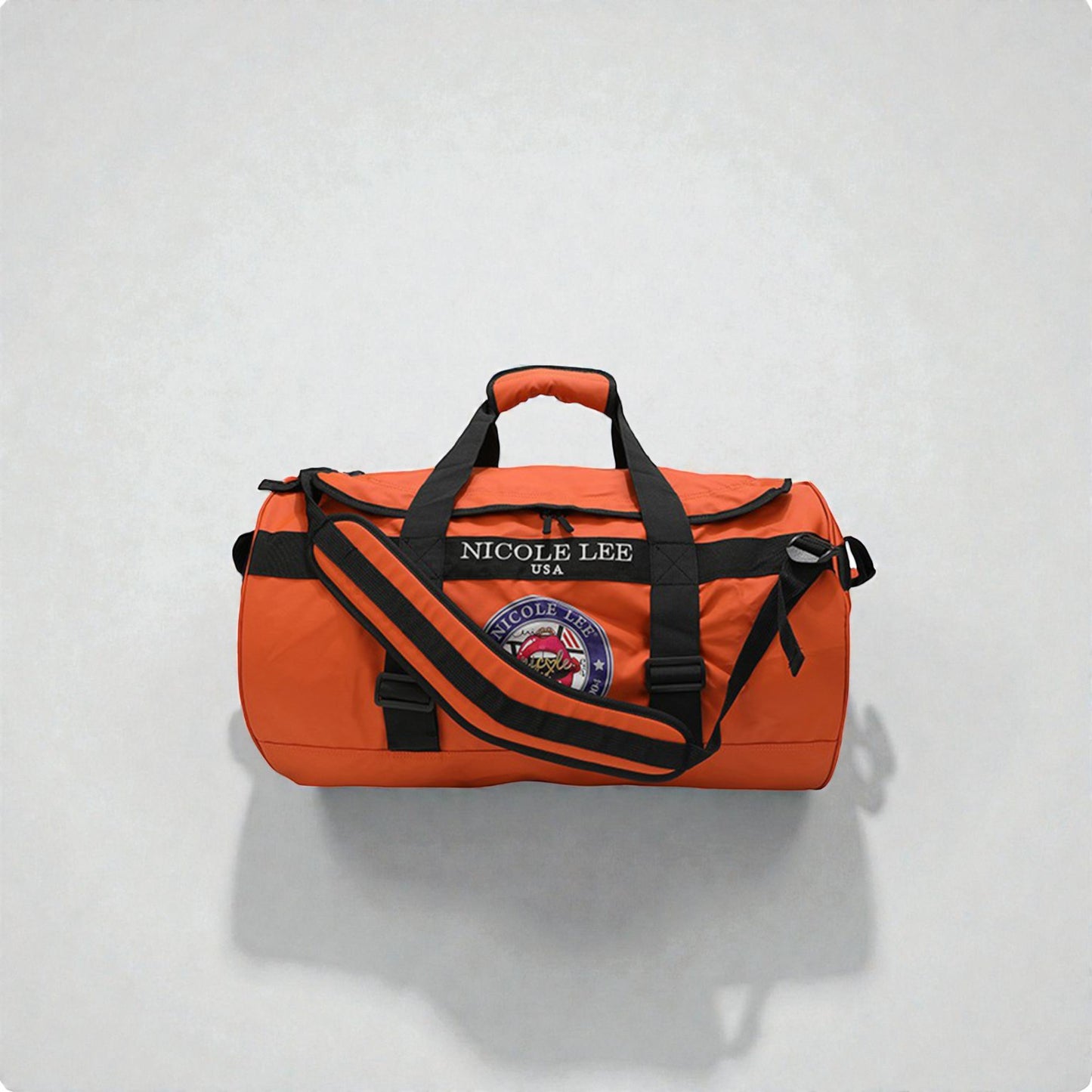 Orange duffel bag with black straps on a light gray background