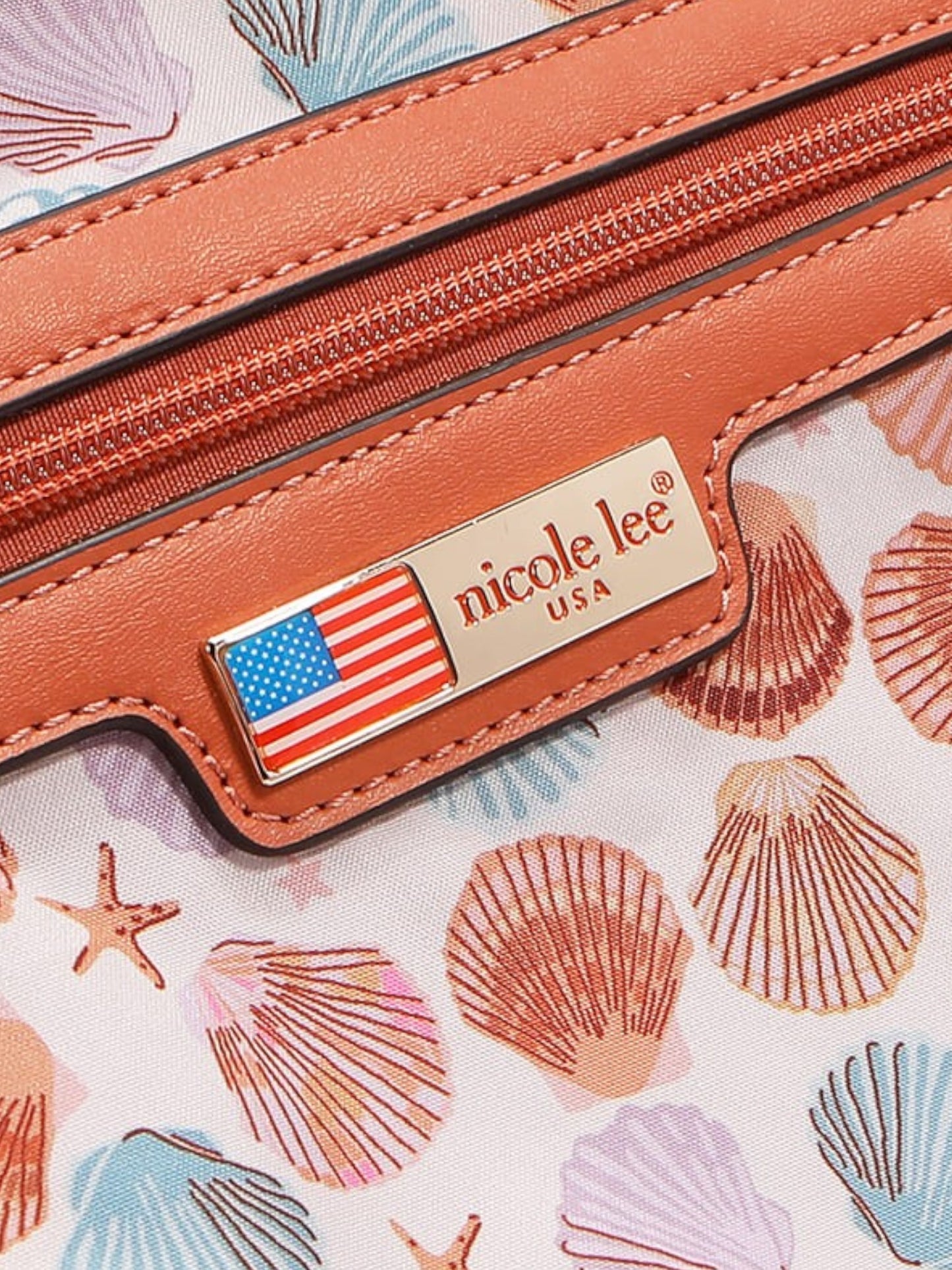 Close-up of a brown leather product with 'nicole lee' label on a shell-patterned background