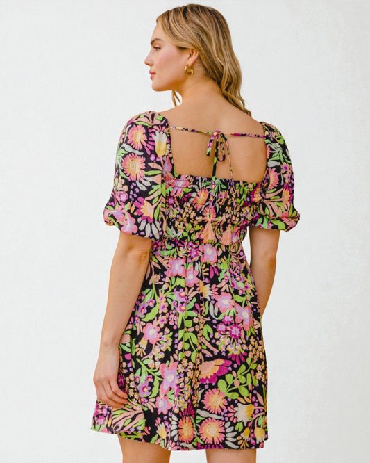 Woman wearing a colorful floral dress on a white background