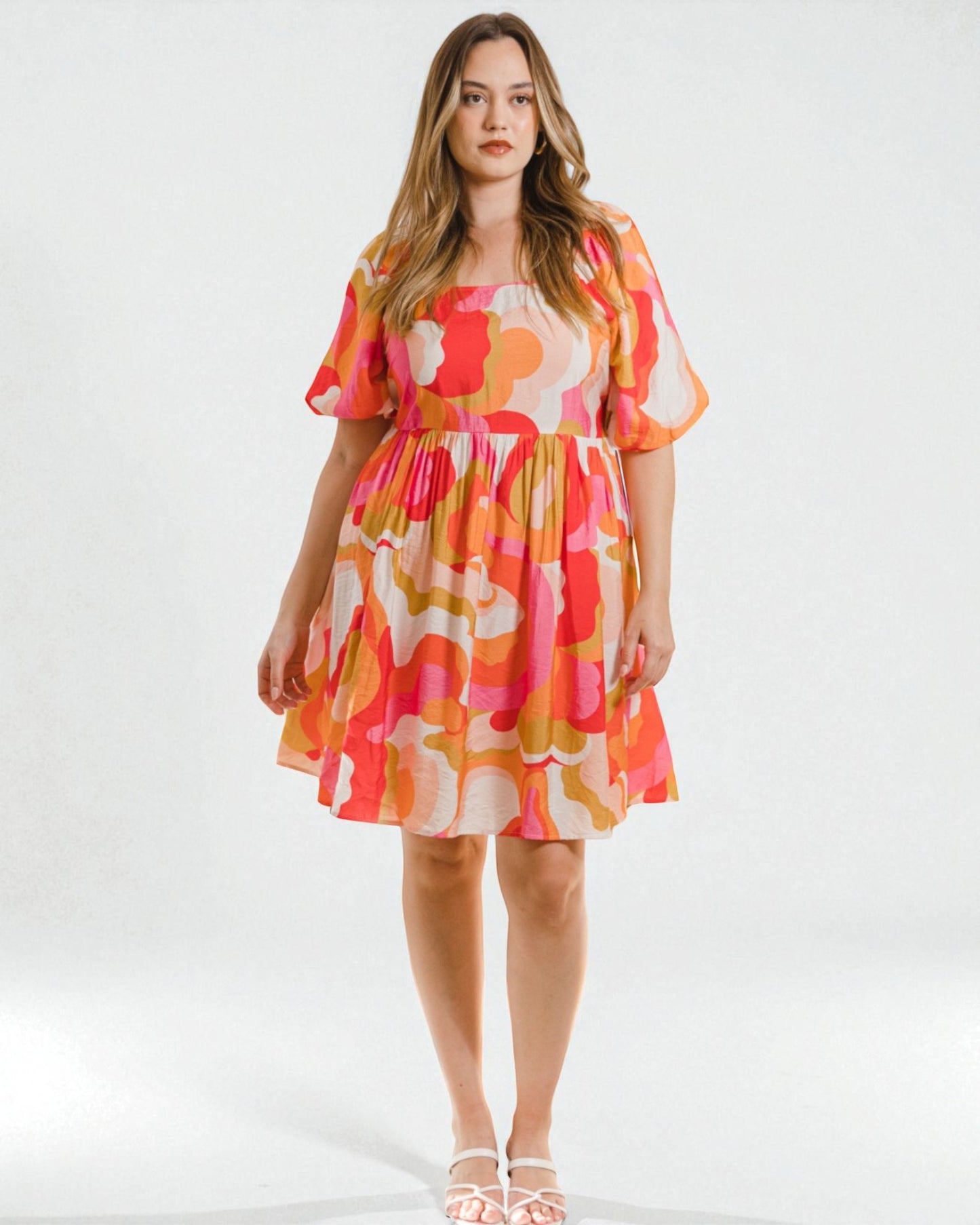 Woman wearing a colorful floral dress on a white background