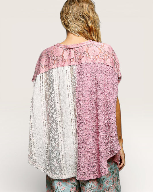 Woman wearing a pink and white patterned top with a plain background