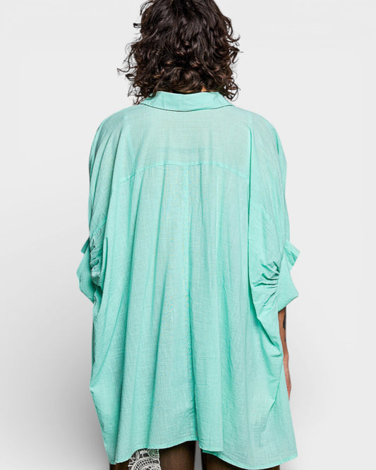 Person wearing a light blue kimono-style garment on a white background