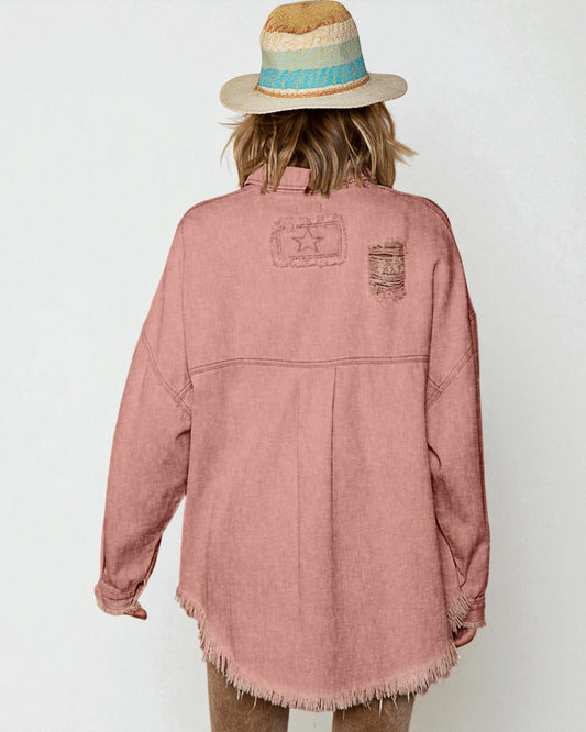 Person wearing a pink denim jacket with back patches on a white background