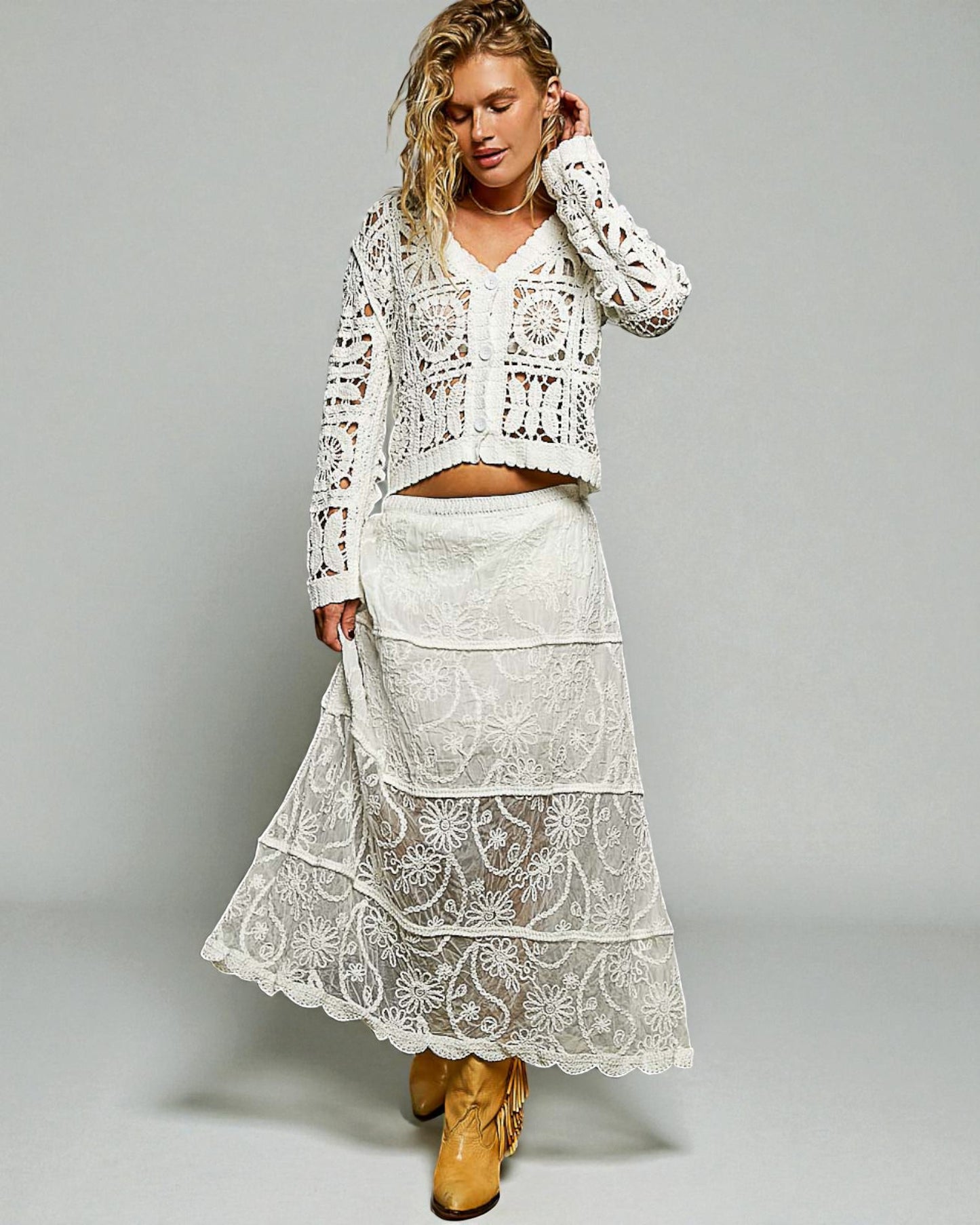 Woman wearing a white lace outfit with a gray background