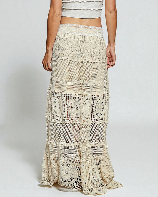 Beige lace skirt worn by a person on a plain background