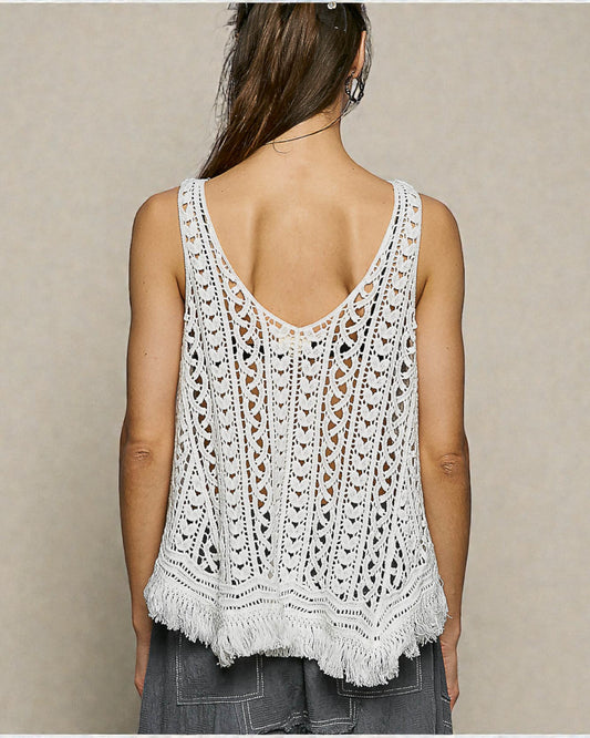 Woman wearing a white crochet tank top against a beige background