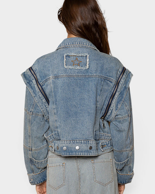 Blue denim jacket with star patch on a white background