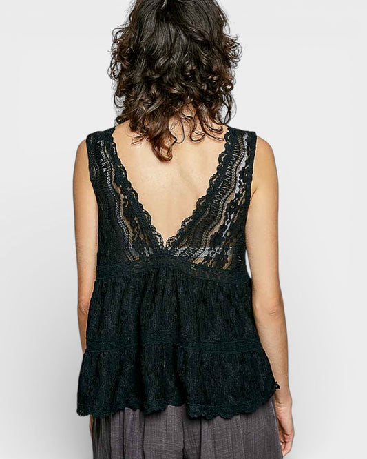 Black lace top worn by a person on a plain background
