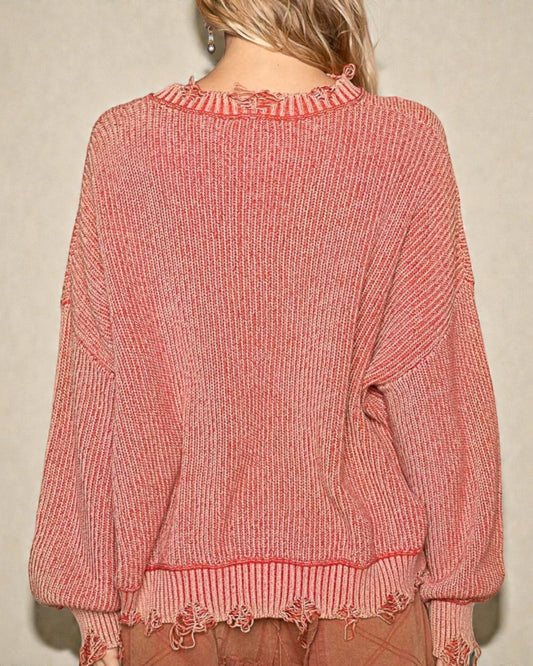 Pink sweater worn by a person against a beige background