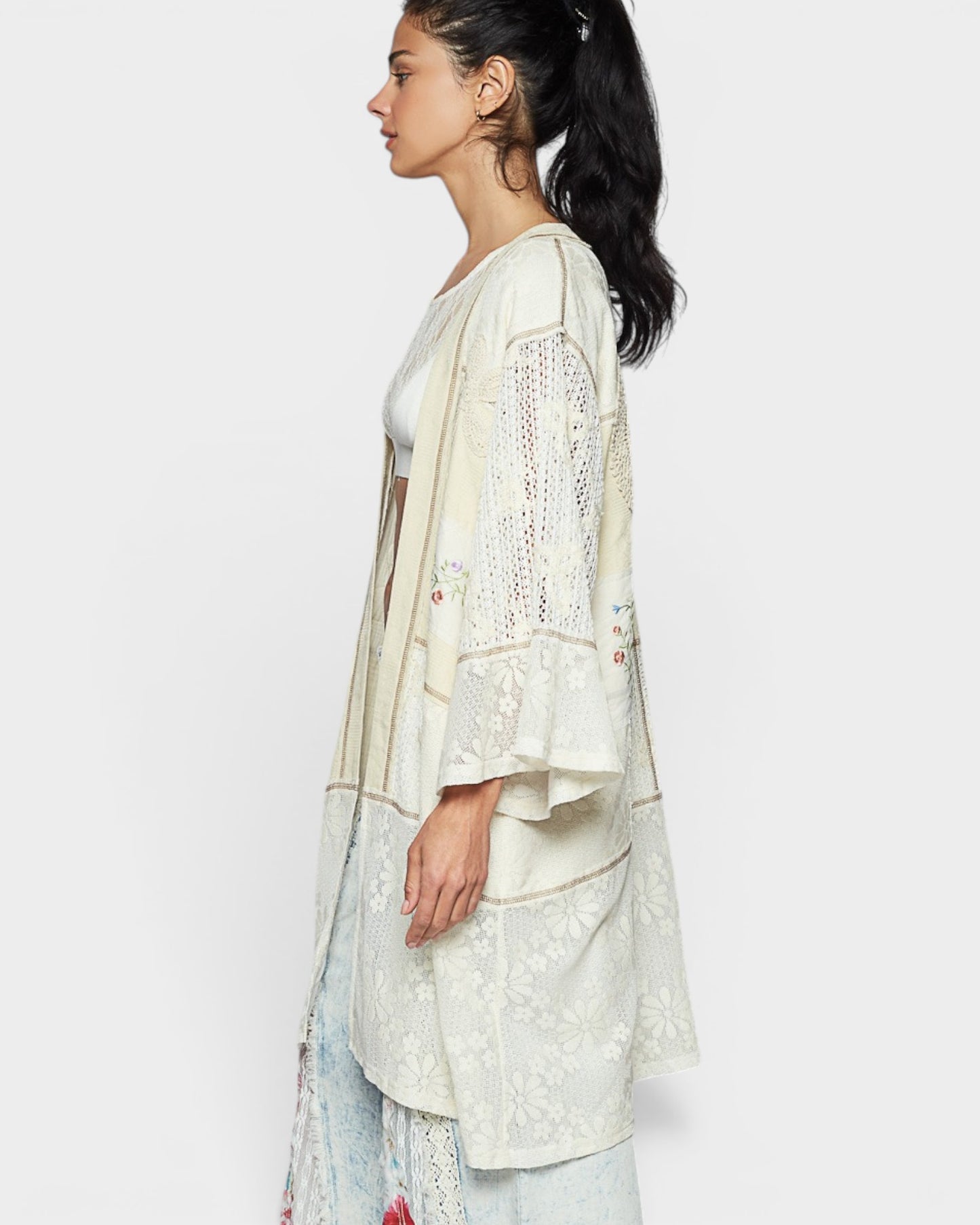Woman wearing a light-colored lace outfit on a white background