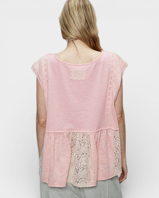 Woman wearing a pink lace-trimmed top on a white background