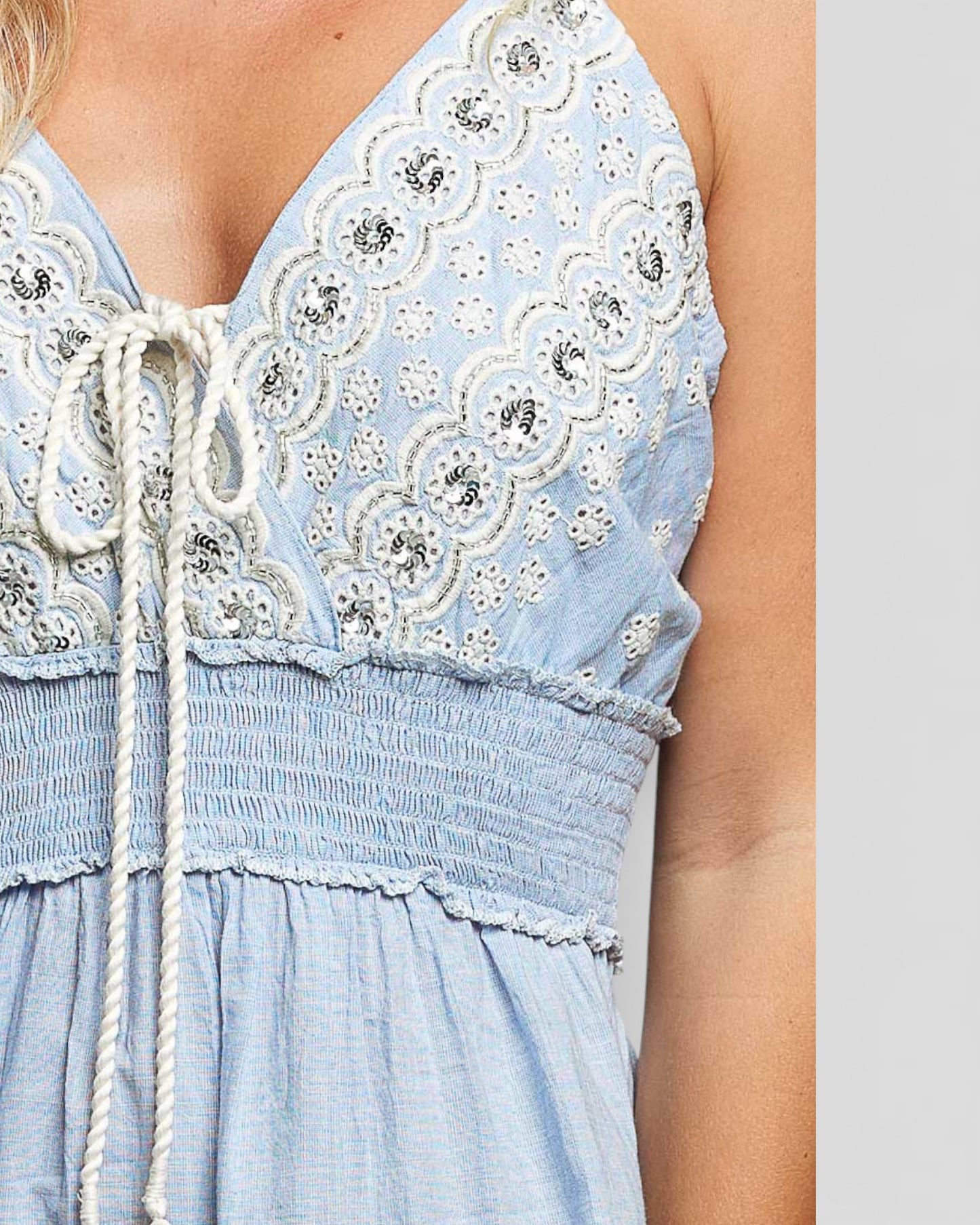 Light blue dress with floral lace details on a plain background