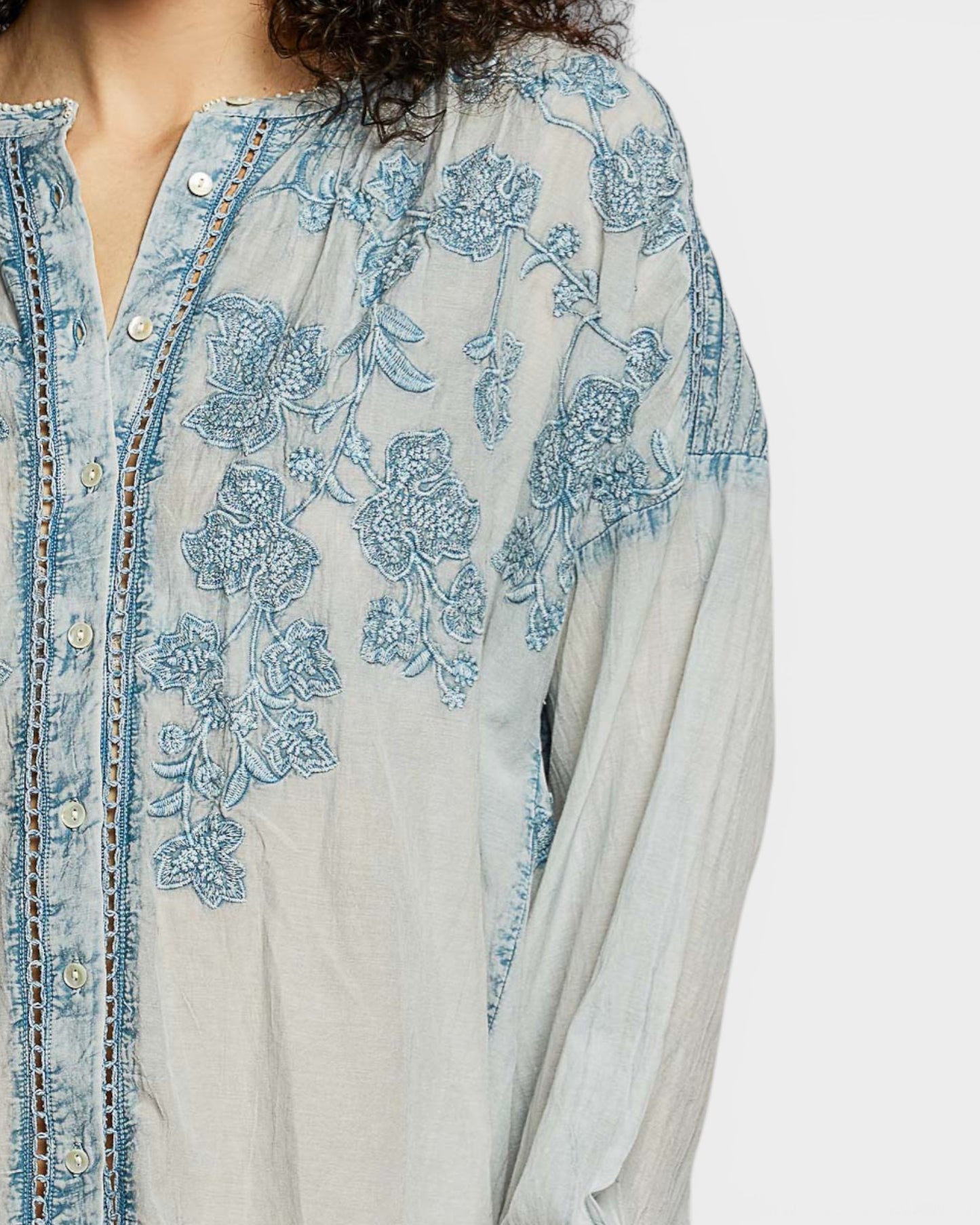 Light blue embroidered shirt with a white background