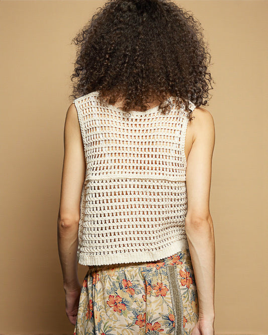 Woman wearing a sleeveless patterned top with a beige background